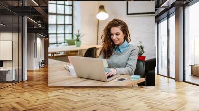 successful young woman in modern office working on laptop. Wall mural