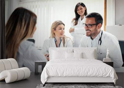 Team of doctors telling good news to a female patient. Wall mural