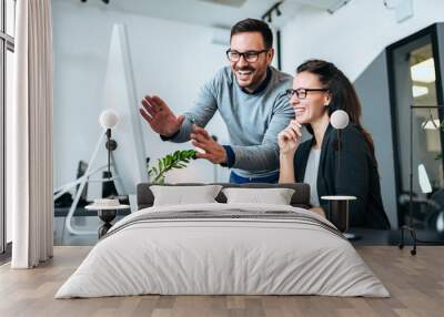 Teawork and success concept. Two business people smiling and looking at computer screen. Wall mural