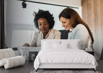 Two beautiful businesswomen working together in the office, portrait. Wall mural