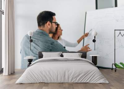 Two colleagues discussing in front of white board. Wall mural