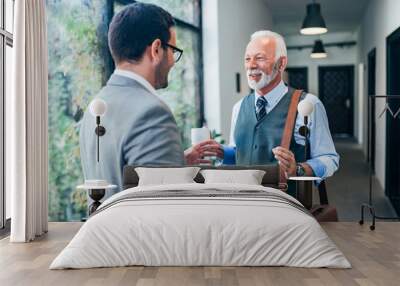 Two male coworkers talking in the hallway. Wall mural