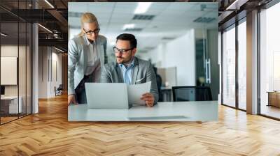 Two serious business people looking at work report or business plan, portrait. Wall mural