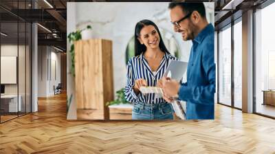 Two smiling colleagues working together, a manager and a sales girl working at the furniture shop. Wall mural