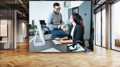 Two young colleagues talking in modern office. Wall mural