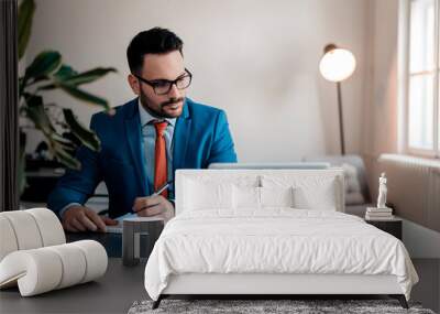 Young businessman working writing notes sitting in a desktop at office. Wall mural