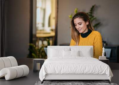 Young female entrepreneur using laptop computer. Wall mural