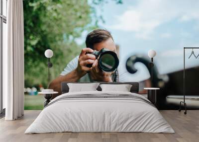 Young photographer at work outdoors. Wall mural