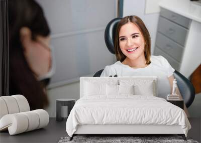 Young smiling woman in dental clinic. Wall mural