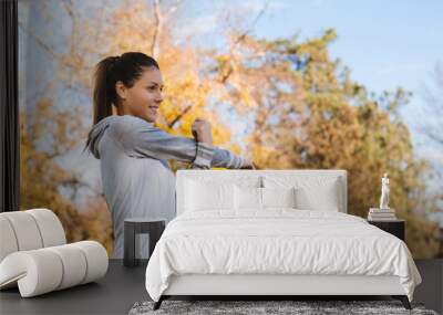 Young woman doing exercises in the park. Wall mural