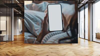 Woman using smartphone in bed Wall mural