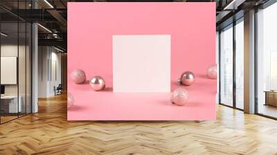 Mock up with square invitation card on trendy pastel light pink background with christmas ornaments. Greeting card and silver Christmas baubles. Minimal christmas concept. Wall mural