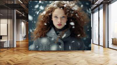 Portrait of young beautiful woman in snowfall, cold winter season Wall mural