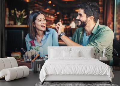 Beautiful young couple sitting in a cafe, having breakfast. Love, dating, food, lifestyle concept Wall mural