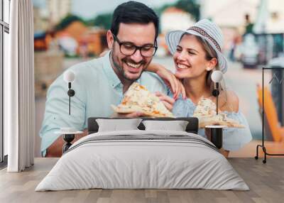 Couple eating pizza outdoors. Dating, consumerism, food, lifestyle concept Wall mural