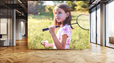 Cute little girl playing a badminton in the park Wall mural