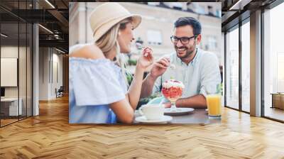 Dating in the cafe. Loving couple drinking coffee and eating fruit desserts. Dating, love, relationships Wall mural