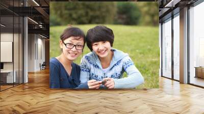 two young asian girl smile at camera outdoor in the park Wall mural