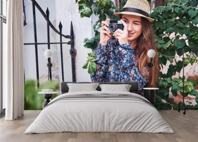 Beautiful young tourist taking photos Wall mural