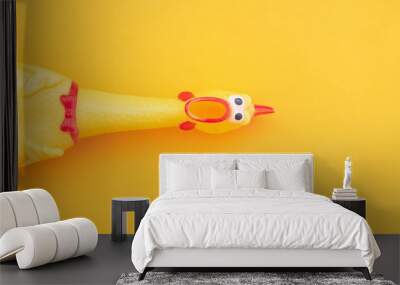 Squeaky chicken toy isolated on a orange background and copyspace. Rubber toy Chicken on a yellow background Wall mural