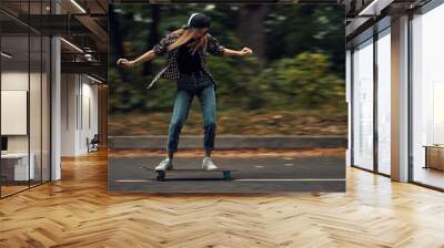 A girl on a skateboard is riding at high speed Wall mural