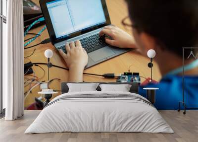 Boy writing code on a laptop Wall mural