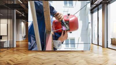 Industrial worker with protective mask welding inox elements in steel structures manufacture workshop. Wall mural