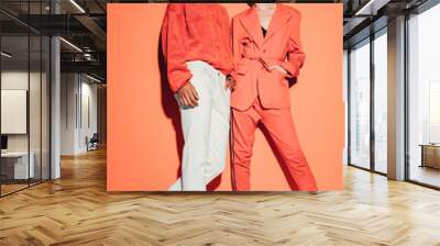 Casual couple in red leaning against a red wall Wall mural