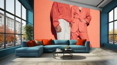 Casual couple in red leaning against a red wall Wall mural