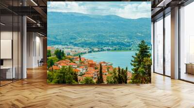 North macedonia. Ohrid. Different buildings and houses with red roofs on lake shore on mountains background Wall mural