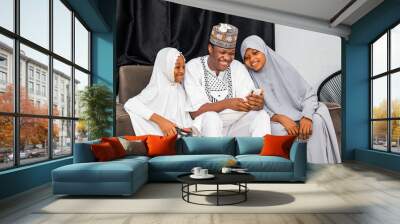 Happy African Muslim family looking at a cellphone Wall mural