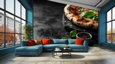 A close-up of a freshly baked pizza with basil leaves and pepper on a dark background. Wall mural