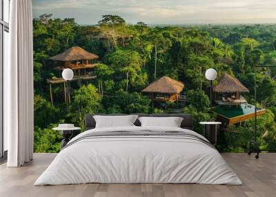 Aerial view of treehouses in a lush green forest, showcasing eco-friendly architecture. Wall mural