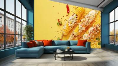 Three ears of corn topped with cheese and spices on a bright yellow background. Wall mural