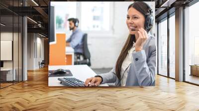 Beautiful young customer care operator with headset and microphone working in call centre Wall mural