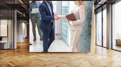 Business Handshake - business people shaking hands. Handshake between business man and woman indoors. Wall mural