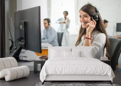 Friendly female customer service helpline operator working on computer in ofice  Wall mural