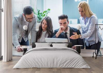 Group of worried and disappointed business people working in office and analyzing bad results from paperwork and laptop during office meeting Wall mural