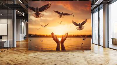 Hands open palm up worship with birds flying over calm water sunset background. Concept of praying for blessing from God. Wall mural