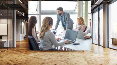 Handsome male supervisor with business team having a meeting at desk in call center. Wall mural