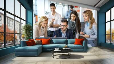 Large group of successful business people working together and discussing project at computer on a meeting in modern office. Wall mural