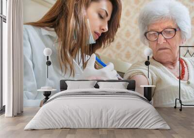 Nurse giving injection to senior woman. Home care. Wall mural