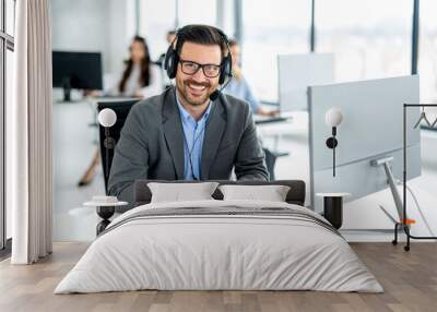 Portrait of friendly male IT help desk technician at call center. Wall mural