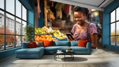 Portrait of smiling african woman using mobile phone in a local market. Wall mural