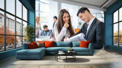 Portrait of successful business people working and discussing documents together in an office. Wall mural