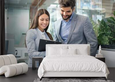 Positive male and female colleagues brainstorming while improving business plan in office Wall mural