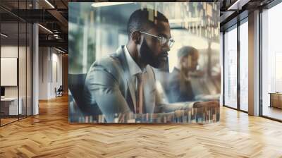 Side view portrait of handsome male businessman working in office with colleagues in the background. Wall mural