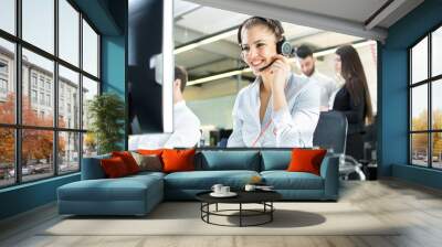 Smiling agent woman with headsets. Portrait of call center worker at office. Wall mural