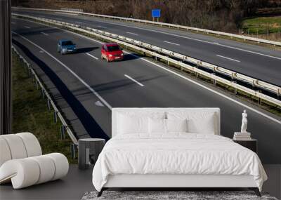 Two cars are driving on a highway. Red and gray car on the highway. Wall mural