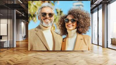 Happy Couple Wearing Sunglasses and Stylish Outfits in Urban Setting Wall mural